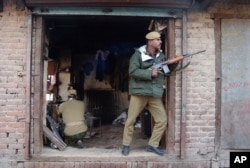 Indian paramilitary soldiers take position in a shop during a gun battle with suspected militants in Srinagar, India, Nov. 23, 2005.