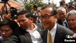Sam Rainsy (kanan), pemimpin partai oposisi Kamboja CNRP, tiba di pengadilan di Phnom Penh (14/1). (Reuters/Samrang Pring)