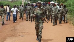 Guinea Bissau soldiers walk on October 21, 2012 in a street of Bissau after gunmen raided a Guinea-Bissau army barracks in the capital, sparking a firefight that left at least seven people dead in the latest unrest to blight the chronically unstable count