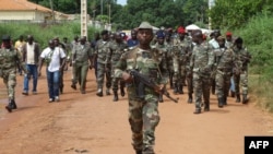 Soldados da Guiné-Bissau caminham no dia 21 de outubro de 2012 numa rua de Bissau depois de homens armados terem invadido um quartel do exército na capital