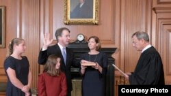 El presidente de la corte de Justicia de EE.UU. John Roberts toma el juramento constitucional a Brett Kavanaugh en Washington, el sábado 6 de octubre de 2018.lLa esposa de Kavanaugh, Ashley, sostiene la Biblia y las dos hijas de la pareja observan la ceremonia. (F. Schilling/Collection of the Supreme Court of the United States)