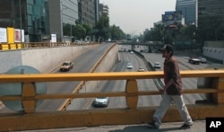 A man walks over what would usually be a very busy thoroughfare in Mexico City, April 6, 2016. City authorities barred millions of vehicles from the streets due to a pollution alert.