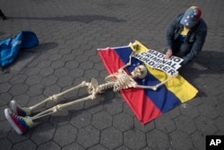 A supporter of Venezuelan opposition leader Juan Guaido secures a skeleton to a Venezuelan flag during a rally in New York's Union Square, April 30, 2019.