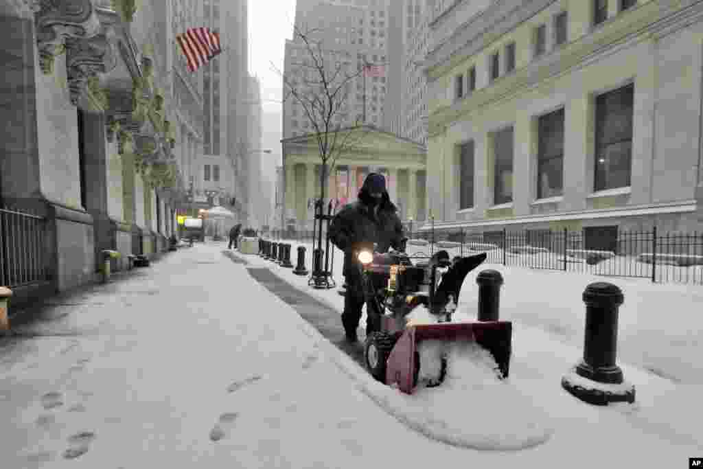 Un homme déblaie la neige devant la Bourse de New York, le 14 mars 2017.