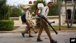 Para petugas pemerintah melakukan penyemprotan nyamuk dari rumah ke rumah di Havana, Kuba Senin (22/2). 