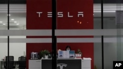 A receptionist works at a Tesla showroom in Beijing, China, Tuesday, Jan. 4, 2022. American-based activists are appealing to Tesla Inc. to close a new showroom in China's northwestern region of Xinjiang.