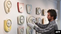 FILE - Master watchmaker Matthias Beck moves the hands of some vintage kitchen clocks at the German Clock Museum in Furtwangen, southern Germany, March 19, 2018.