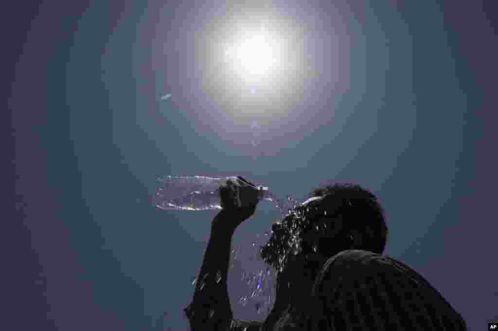 A man pours water on his face during a severe heat wave, in Hyderabad, May 24, 2015.