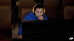 Seorang pria menggunakan komputer di warung Internet di Beijing, China. (Foto: Dok)