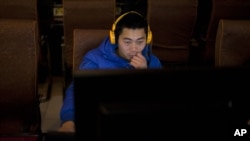 A man uses a computer at an internet cafe in central Beijing, China.