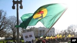 A Congolese protester waves a flag of the former Zaire in front of the White House Saturday, December 10, 2011, denouncing recent election results in the Democratic Republic of Congo.