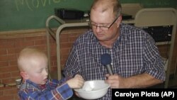 Eric Kuhlman, 3, helps master of cermonies Stan Miller draw names for the annual Norcatur drawing.