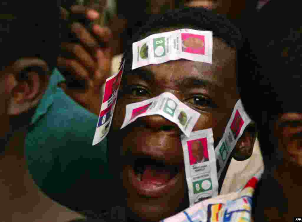 A supporter of Haiti's presidential candidate Michel Martelly, with Martelly's electoral stickers on his face, waits to meet the candidate outside his home in Peguy Ville December 9. (St-Felix Evens/Reuters)