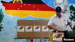 A man casts his ballot in a box during a municipal elections in Caracas, Venezuela, Dec. 8, 2013. 
