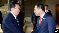 韩国代表团团长金奎显（右）在板门店与朝鲜代表团团长元东渊握手（2012年2月12日）