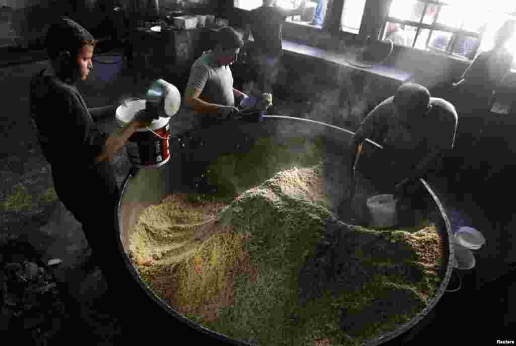 Workers prepare food for distribution to residents and those displaced in the city of Raqqa, Syria, Oct. 7, 2013. 