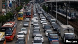 Motorists drive through a heavy traffic flow near a passing metro train along the main highway EDSA in Makati, Metro Manila, Philippines, June 21, 2016.