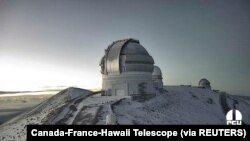 Gambar diam dari video timelapse menunjukkan salju di puncak Mauna Kea di Hawaii, AS, 2 Desember 2021. (Foto: Canada-France-Hawaii Telescope via REUTERS)