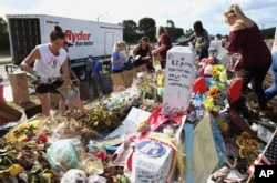 Volunteers, students and parents sort items left at the memorial site for the 17 students and faculty killed at Marjory Stoneman Douglas High School, March 28, 2018 in Parkland, Florida. Flowers and plants will be composted while all other items will be will be catalogued and saved.