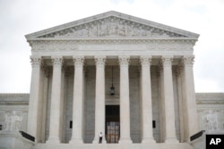 In this Oct. 9, 2018 photo, police office guards the main entrance to the Supreme Court in Washington.