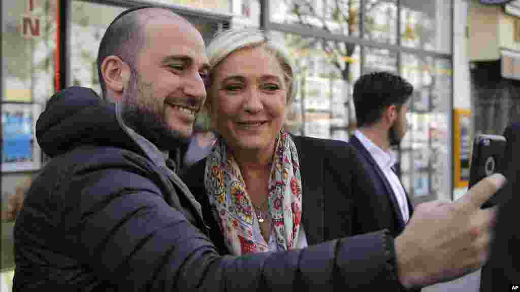 Yar takara mai ra&#39;ayyin majen jiya Marine Le Pen na daukar hoto tare da wani dake goyon bayanta, ranar Litinin 24 ga watan Afrilu na shekarar 2017.