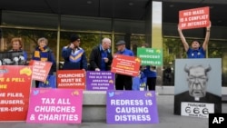 Protesters gather outside the County Court during the sentencing of Cardinal George Pell in Melbourne, Australia, Wednesday, March.13, 2019. (AP Photo/Andy Brownbill)