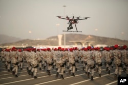 FILE - In this Thursday, Sept. 17, 2015 file photo, a drone is used to record a military parade by Saudi security forces in preparation for the annual Hajj pilgrimage in Mecca, Saudi Arabia. The war in Yemen is costing the Kingdom $200 million a day.