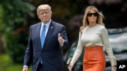 President Donald Trump, accompanied by first lady Melania Trump, gives a thumbs-up as they walk across the South Lawn of the White House in Washington, May 19, 2017.