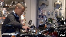 Harley owner Roberto White Pintu checks out a bike at the Bastille shop. (L. Bryant/VOA)