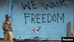 FILE - Graffiti is painted on shop shutters in Srinagar after an escalation of violence that officials blamed on separatist protests that have tied down security forces for more than a month in Kashmir, Aug. 17, 2016. 