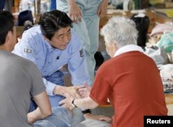 아베 일본 총리가 11일 오카야마현 쿠라시키시의 대피 시설을 찾아 이재민들을 위로하고 있다.