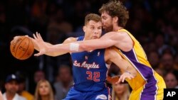 Blake Griffin (azul) de los Clippers y Pau Gasol, de los Lakers disputan un balón en juego inaugural de la temporada 2013 de la NBA.