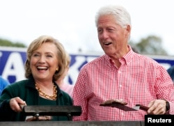 FILE – Former U.S. Secretary of State Hillary Clinton and ex-President Bill Clinton submit to grilling at a steak fry in Indianola, Iowa, Sept. 14, 2014. She’s seeking his old job.