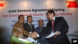 中方和印尼官员在签订中方承建印尼高铁的合同后握手（2015年10月16日）