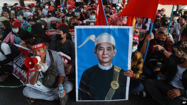 FILE - An image of deposed Myanmar President Win Myint is displayed at an anti-coup rally in Yangon, Myanmar, Feb. 20, 2021.