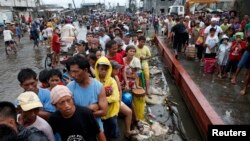 Typhoon victims line up for free rice at a businessman's warehouse in Tacloban city, which was battered by Typhoon Haiyan, in central Philippines. Nov. 12, 2013.