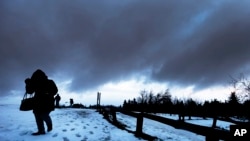 Una mujer camina en medio de una fuerte tormenta en la montaña Feldberg, cerca de Frankfurt, Alemania. Enero 3, 2017.