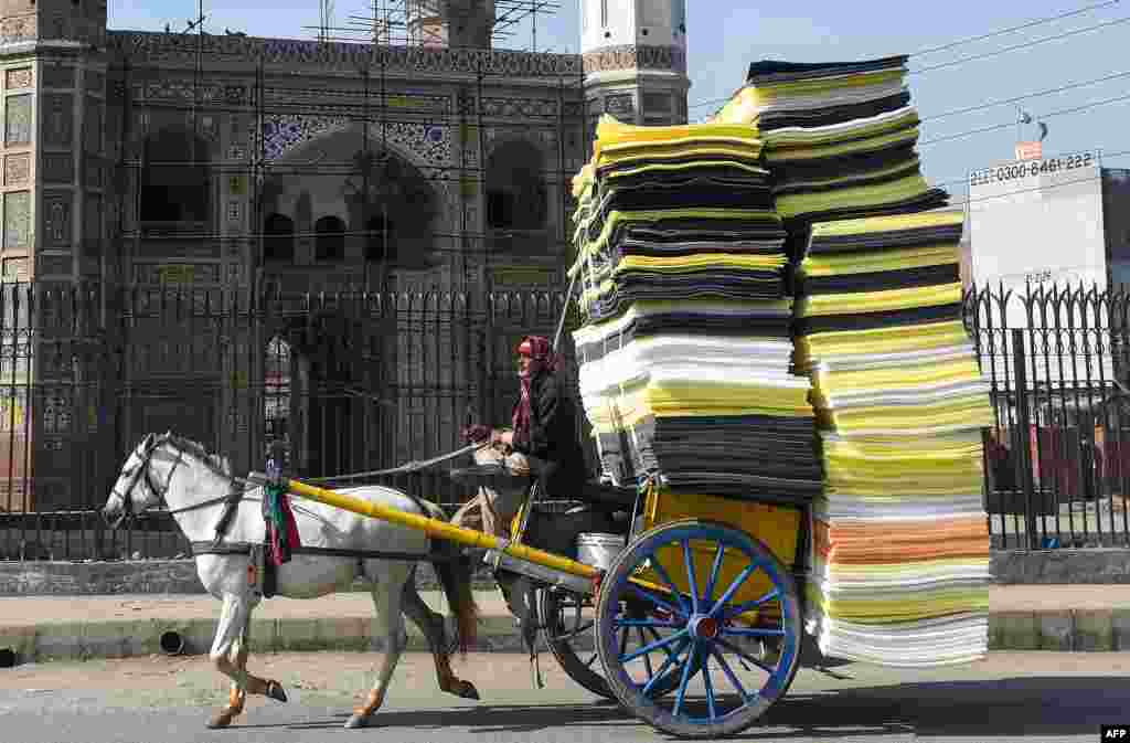 A man drives a horse-drawn carriage loaded with foam sheets on a street in Lahore, Pakistan, Jan. 29, 2019.