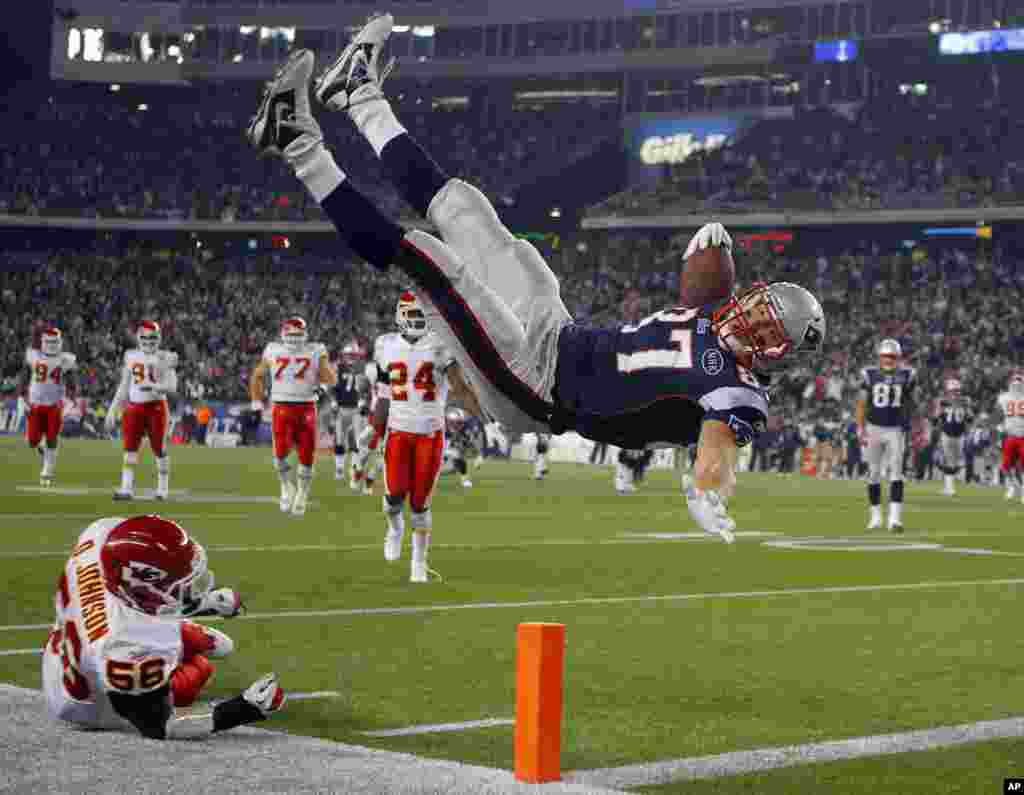 New England Patriots tight end Rob Gronkowski (top) scores a touchdown over Kansas City Chiefs linebacker Derrick Johnson in the second half of their NFL football game in Foxborough, Massachusetts November 21, 2011. REUTERS/Brian Snyder (UNITED STATE