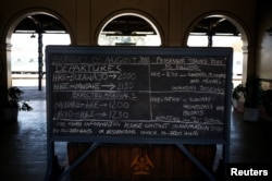 A train schedule is written on a chalk board at a train station in Harare, Zimbabwe, Aug. 5, 2018.