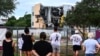 People watch as crews begin to demolish the building where seventeen people were killed during the 2018 mass shooting at Marjory Stoneman Douglas High School in Parkland, Florida, on June 14, 2024.