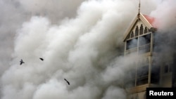 FILE - Taj hotel is seen engulfed in smoke during a gunbattle in Mumbai, Nov. 29, 2008. 