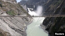 Labors walk on a bridge near the new 450-megawatt hydropower project located at Baglihar Dam on the Chenab river which flows from Indian Kashmir into Pakistan, Oct. 10, 2008. 