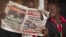 FILE - A Kenyan reads a copy of The Standard newspaper in Nairobi.