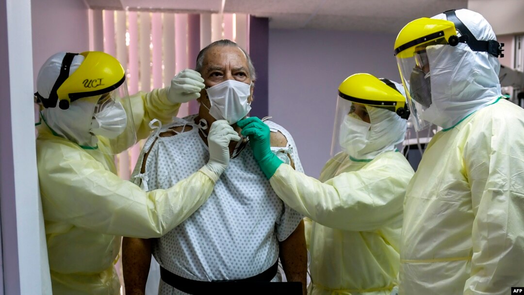 FILE - In Panama, a patient with a confirmed case of COVID-19, is surrounded by a medical team at the intensive care unit of Paitilla Hospital in Panama City, May 6, 2020.