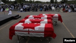 Empat peti jenazah anggota keluarga Afzaal yang dibunuh dalam serangan kebencian diselimuti bendera Kanada di Islamic Centre di barat daya Ontario, di London, Ontario, Sabtu, 12 Juni 2021. 