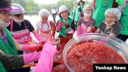 9일 서울 양천구청 주최로 열린 '다문화 여성 및 북한이탈주민 전통 고추장 담그기' 행사에서 참석자들이 새마을 부녀회 회원들의 도움으로 고추장을 담그고 있다. 