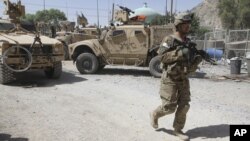 A US soldier, part of the NATO forces, patrols a police station after it was attacked by militants in Kandahar, south of Kabul, Afghanistan, June 19, 2012.