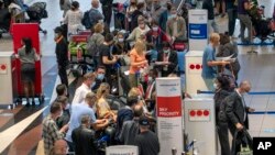 People line up to get on the Air France flight to Paris at OR Tambo International Airport in Johannesburg, South Africa, Friday Nov. 26, 2021. A slew of nations moved to stop air travel from southern Africa on Friday in reaction to news of a new COVID-19 variant.