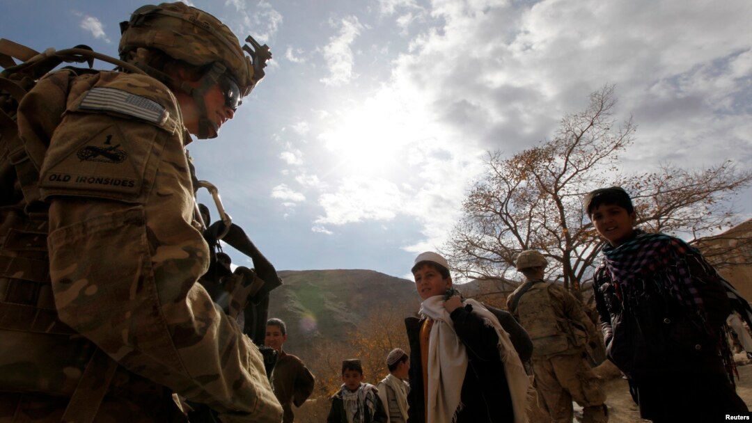 Seorang tentara AS (kiri) dikelilingi oleh anak-anak dan remaja setempat, saat melakukan patroli di provinsi in Wardak, Afghanistan timur (foto: dok). 